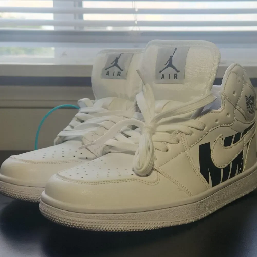 Brand new men’s white mid-top sneakers with a bold black graphic side design